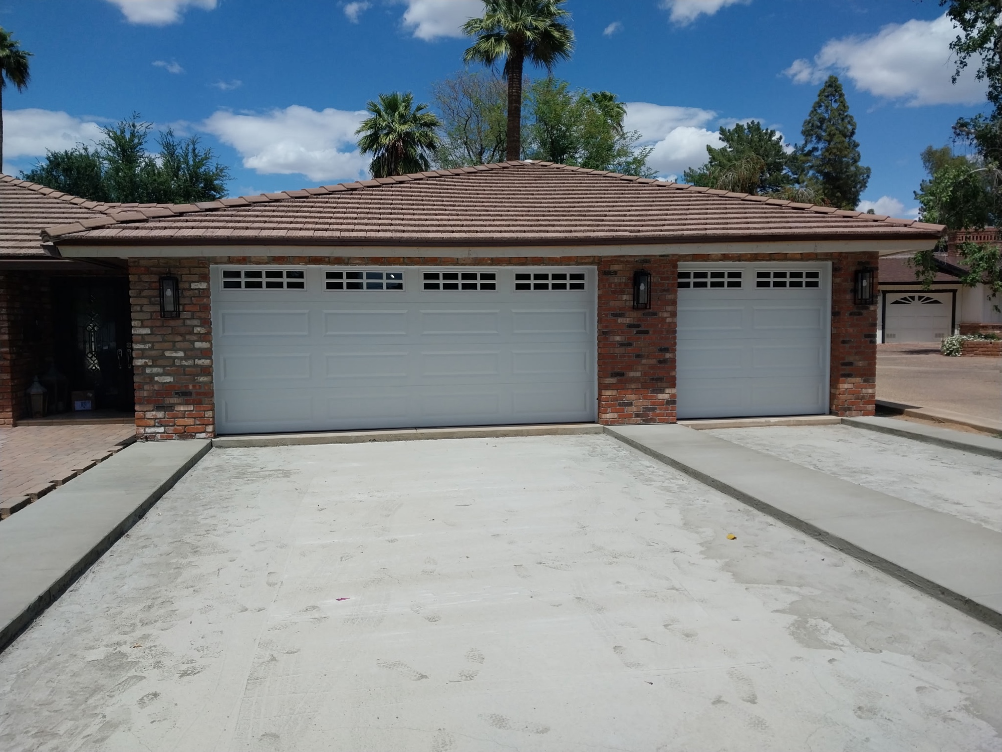 White carriage-style garage door with window inserts after tune-up service